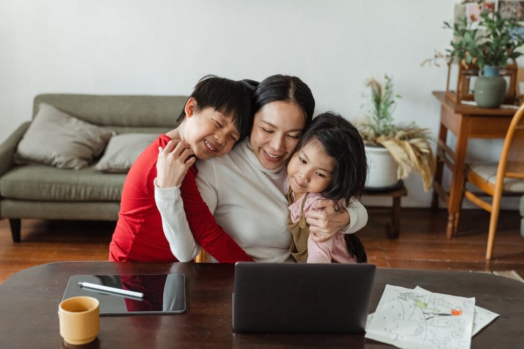 work from home mother hugging her kids